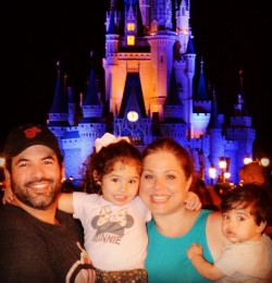 Image Depicts paralegal Jorge Miranda, his wife and two children in front of Cinderella's Castle at Disney