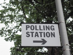 A polling Station Sign with an arrow pointing to the right
